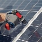 Engineer in a white helmet. Man near solar panel.